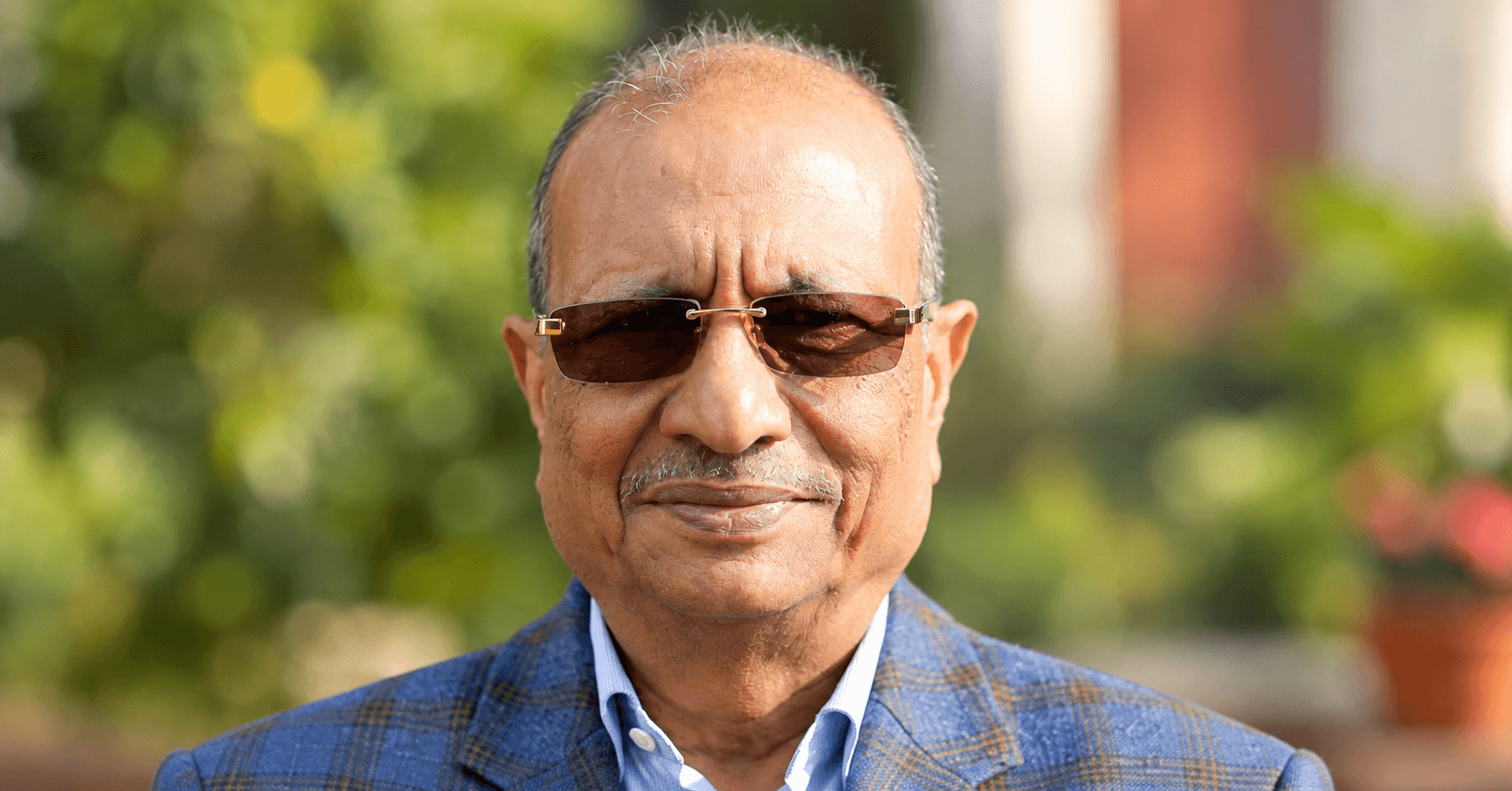 Close-up portrait of industrialist Shankar Lal Agrawal wearing tinted glasses.