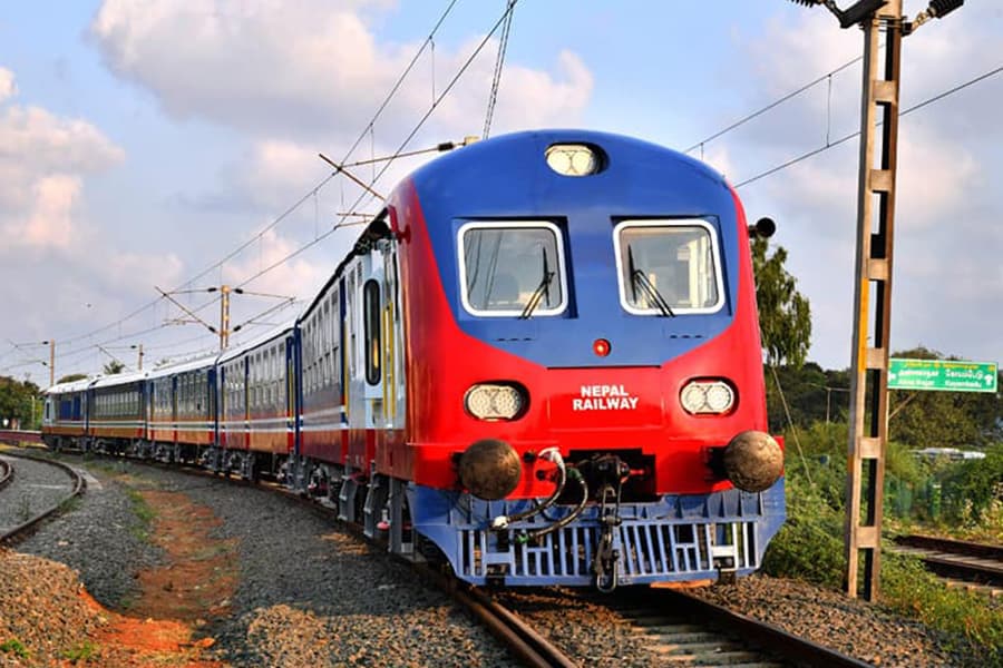 A Nepal Railway train traveling on tracks.