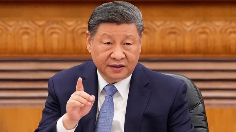 Chinese President Xi Jinping sitting at a desk and gesturing with his finger.