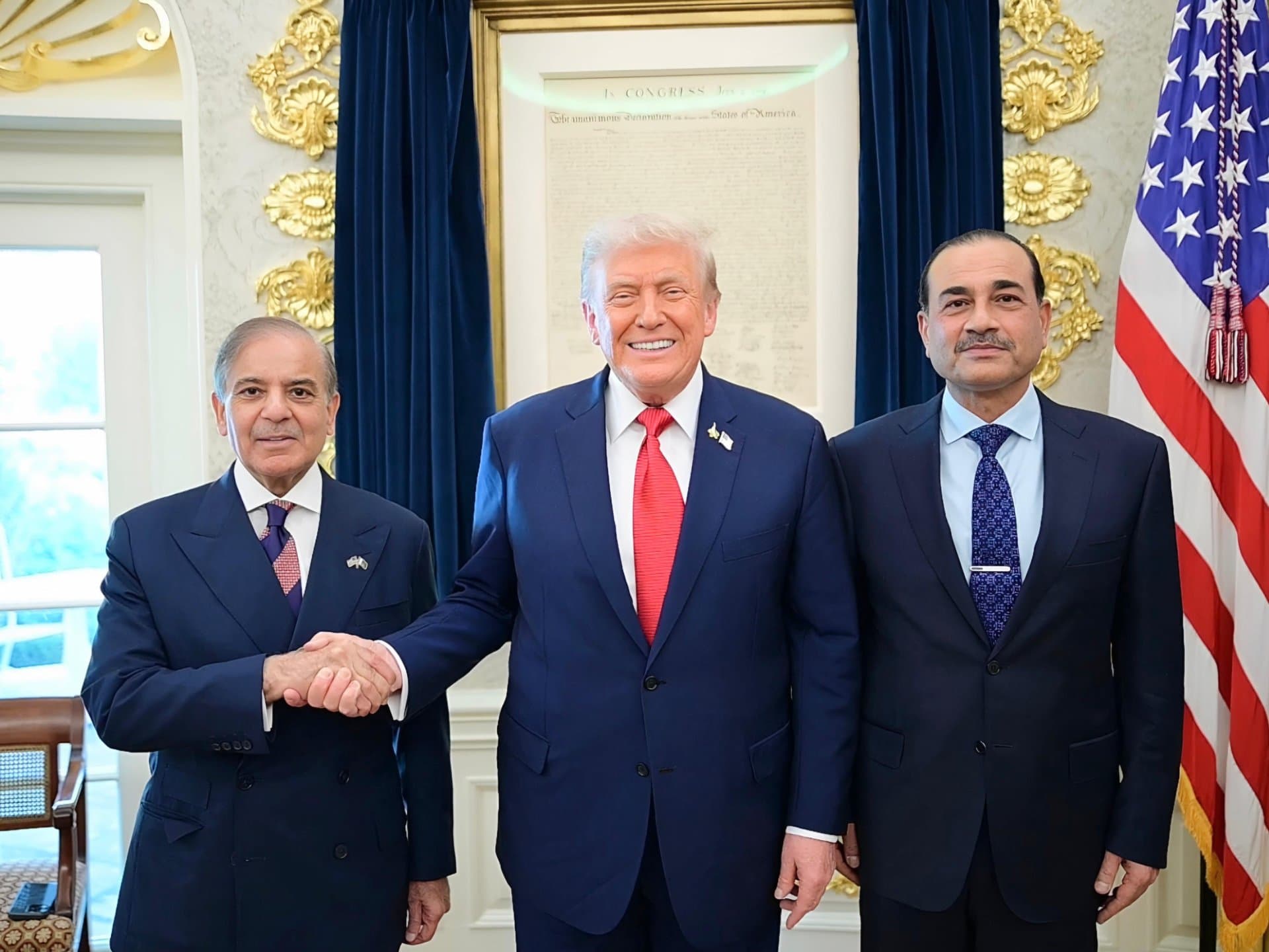 Donald Trump shaking hands with a Pakistani official.