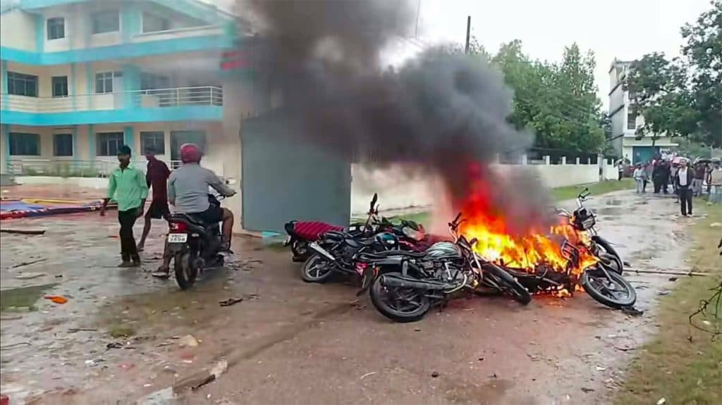 Motorcycles burning in front of a hospital building during a protest.