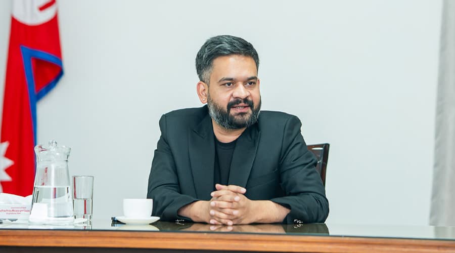 Prime Minister Balen Shah sitting at a desk with his hands clasped.