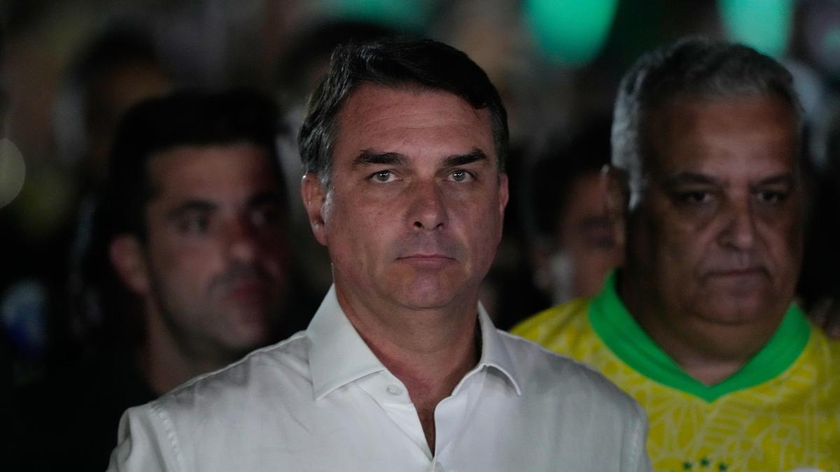 Flávio Bolsonaro appearing serious in a crowd.