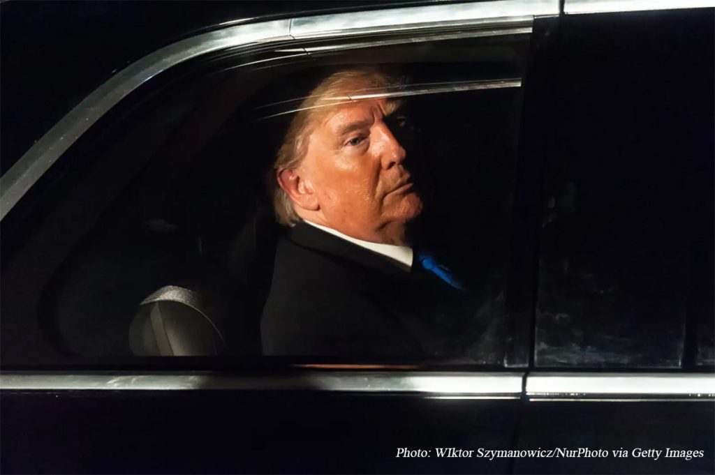 Donald Trump looking out from the window of a car.