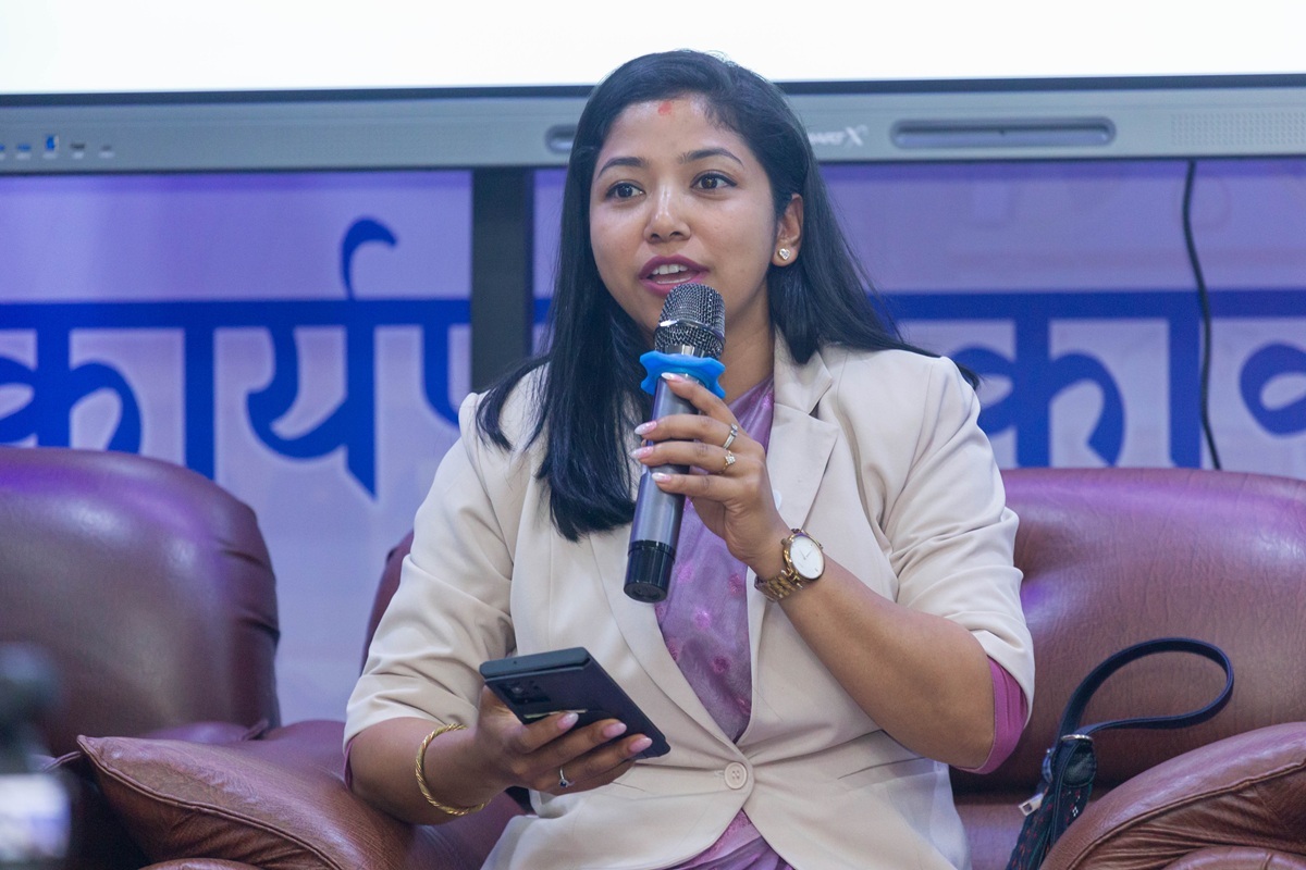Acting Mayor Sunita Dangol speaking into a microphone while holding a phone.