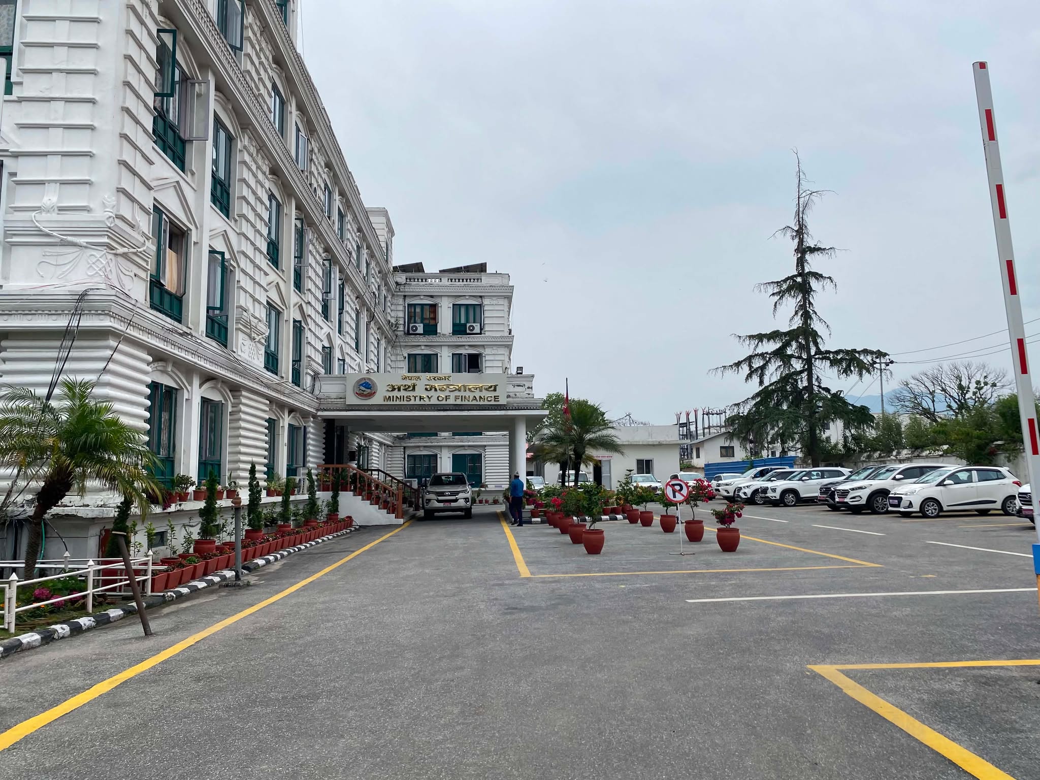 The exterior of the Ministry of Finance building and its parking lot.