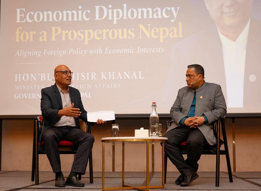 Foreign Minister Shishir Khanal and journalist Kuber Chalise seated on stage during an interactive session on economic diplomacy.
