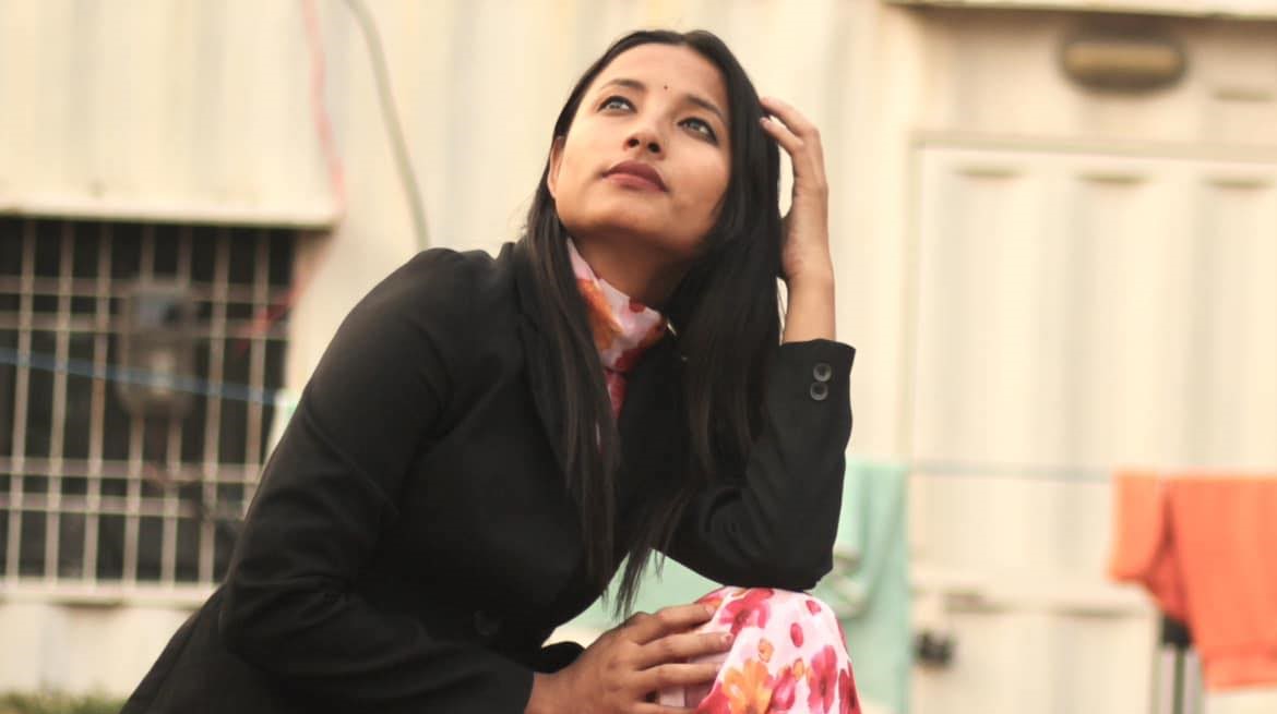 A portrait of activist Raksha Bam looking upwards.