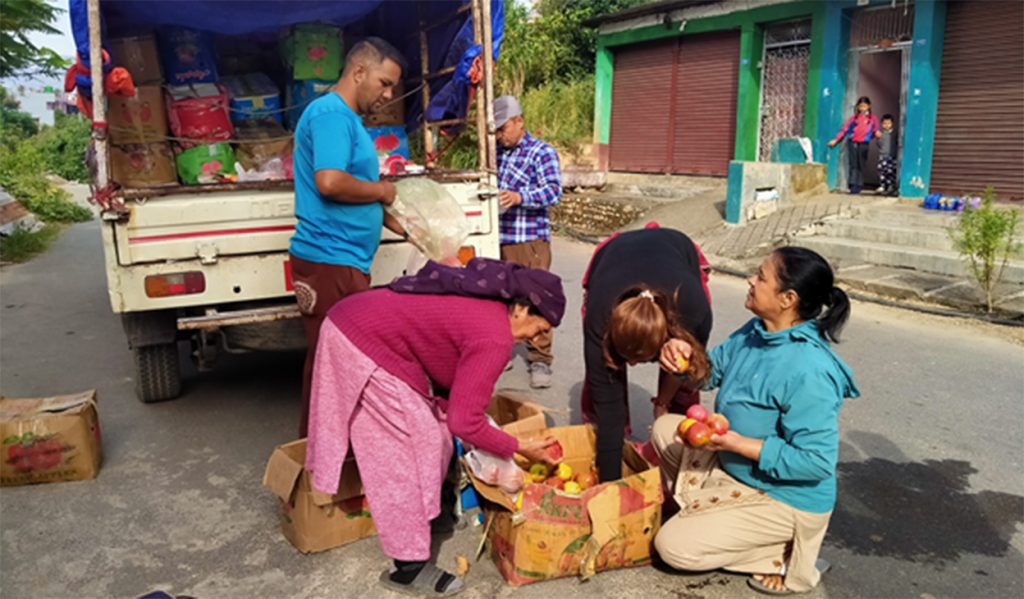 People purchasing apples directly from a truck.